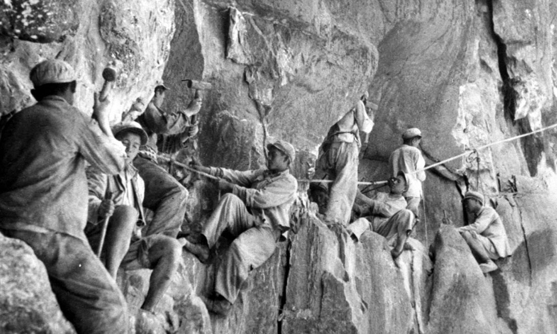 1954年，修筑康藏公路的解放軍戰士們在怒江兩岸的懸崖陡壁上辟山筑路。新華社稿 李萬春、張加里攝