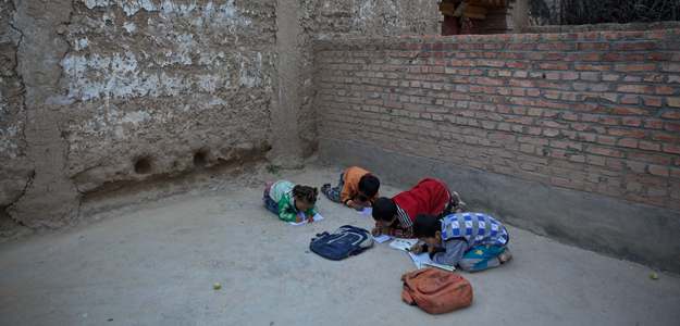 趴在地上做作業的孩子們